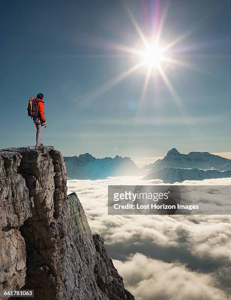 climber looking out from peak emerging from fog in the alps, bettmeralp, valais, switzerland - sunshine summit stock-fotos und bilder