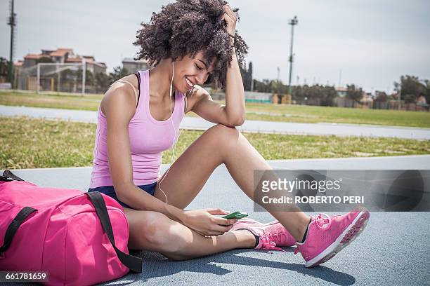 young woman training, taking a break on running track - gym bag fotografías e imágenes de stock