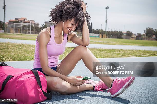 young woman training, taking a break on running track - gymtas stockfoto's en -beelden