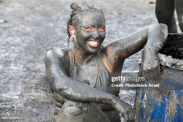 portrait of woman covered in therapeutic mud, dead sea, israel - fango stock-fotos und bilder