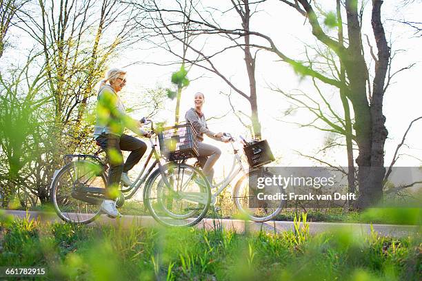 side view of women cycling on bicycles - cycling netherlands stock pictures, royalty-free photos & images