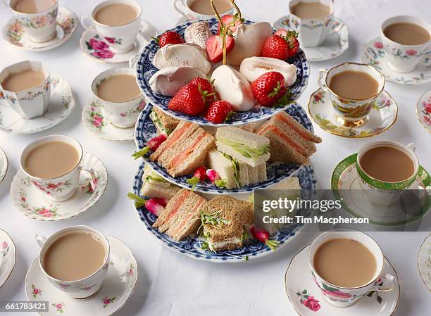 vintage tea cups and sandwiches on cakestand prepared for afternoon tea - afternoon tea stock pictures, royalty-free photos & images