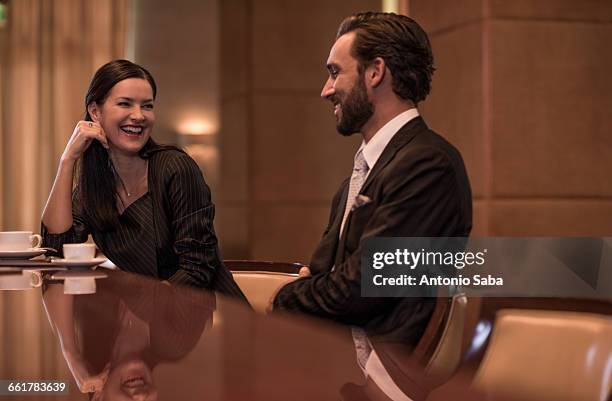 businesswoman and man flirting at hotel bar - versierd jak stockfoto's en -beelden