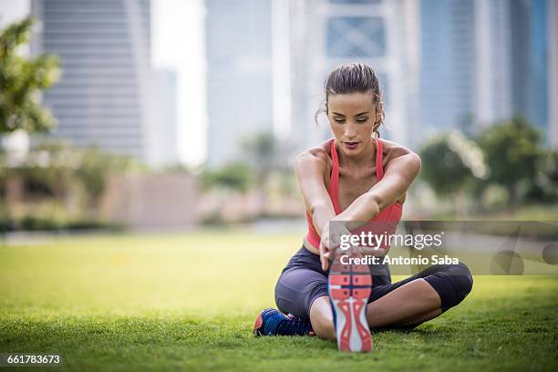 woman practicing yoga in park, dubai, united arab emirates - yoga office arab stock pictures, royalty-free photos & images