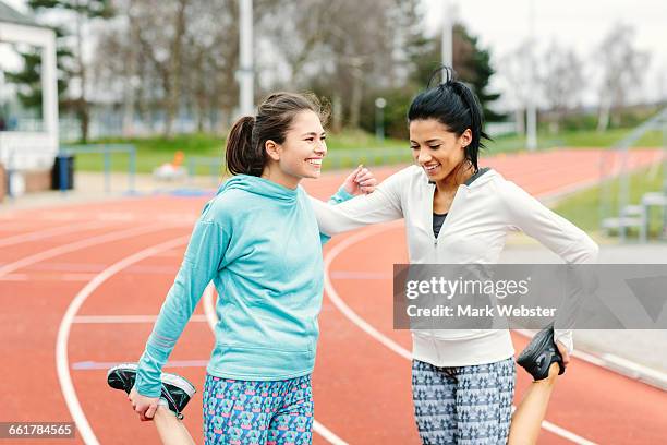 two young women on running track, exercising, stretching - live at leeds 2016 stock pictures, royalty-free photos & images