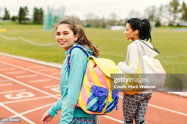 two young women walking on running track, carrying sports bags, rear view - gym bag 個照片及圖片檔