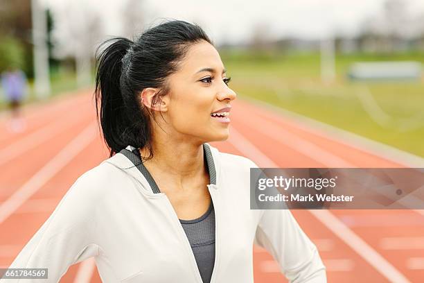 portrait of young girl on running track, looking away, smiling - live at leeds 2016 stock pictures, royalty-free photos & images