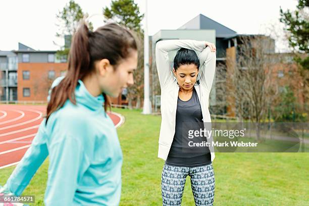 two young women outdoors, exercising, stretching - live at leeds 2016 stock pictures, royalty-free photos & images