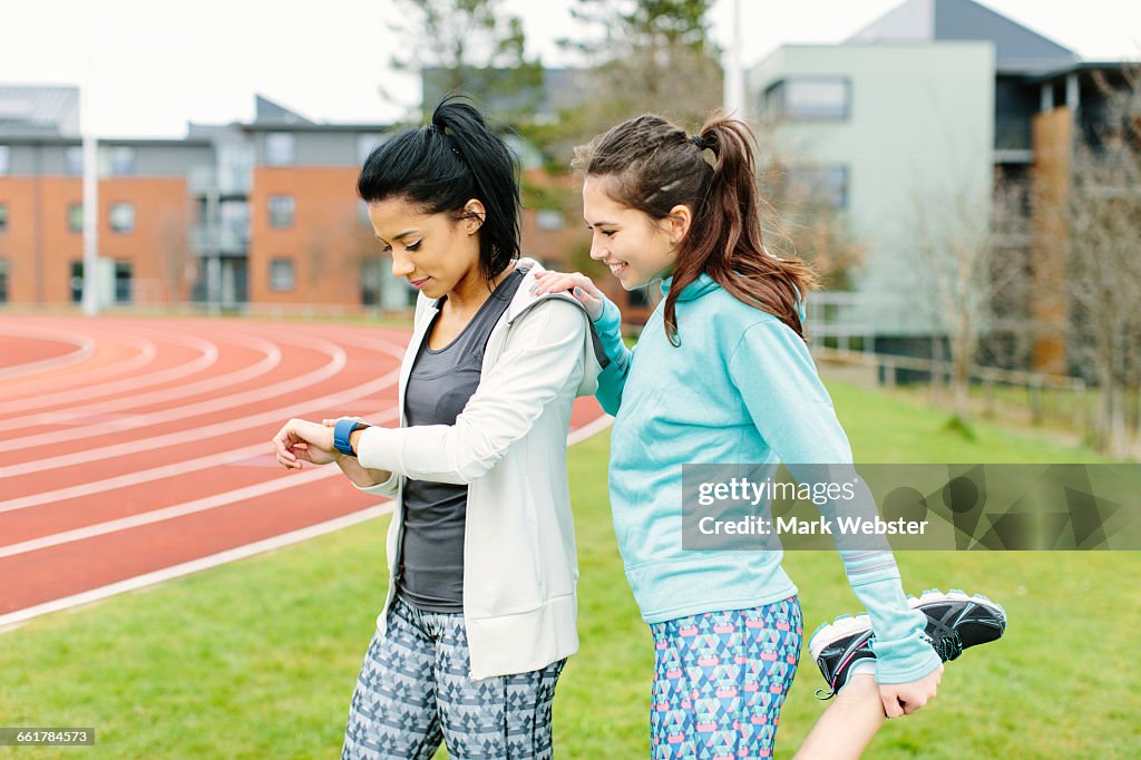 Two young women outdoors, exercising, stretching