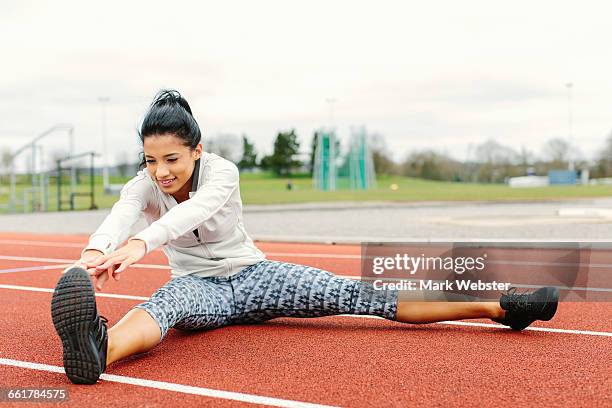 young woman on running track, exercising, stretching - live at leeds 2016 stock pictures, royalty-free photos & images