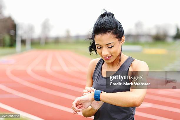 young woman on running track, checking watch - live at leeds 2016 stock pictures, royalty-free photos & images