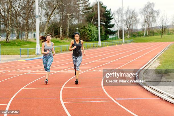 two young women running on running track - live at leeds 2016 stock pictures, royalty-free photos & images