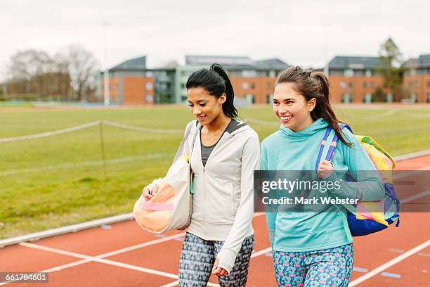 two young women walking on running track, carrying sports bags - live at leeds 2016 stock-fotos und bilder