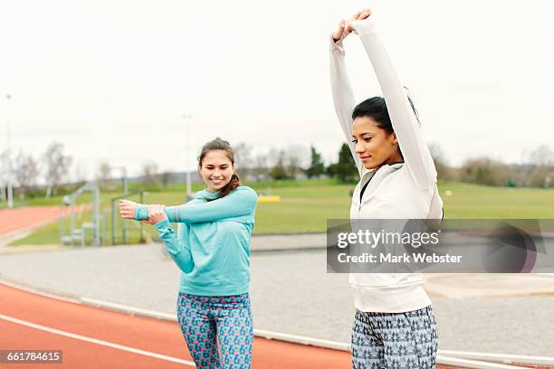 two young women on running track, exercising, stretching - live at leeds 2016 stock pictures, royalty-free photos & images