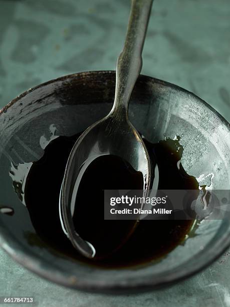 pomegranate molasses in bowl with spoon, close-up - molasses stock pictures, royalty-free photos & images