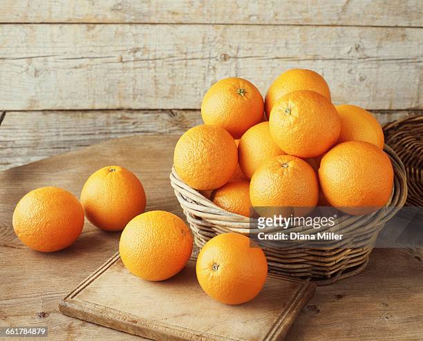 oranges in wicker basket - orange fotografías e imágenes de stock