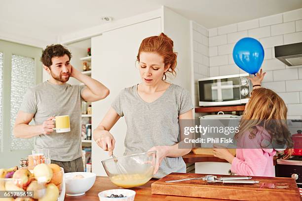 mid adult woman whisking eggs at kitchen counter for family breakfast - whipping woman stock pictures, royalty-free photos & images