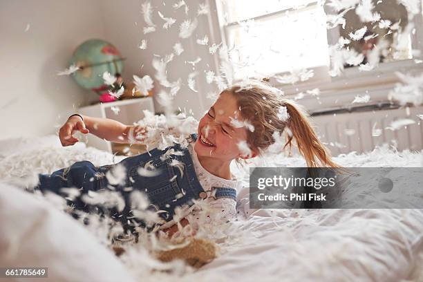 girl falling on feather pillow fight bed - kids misbehaving fotografías e imágenes de stock