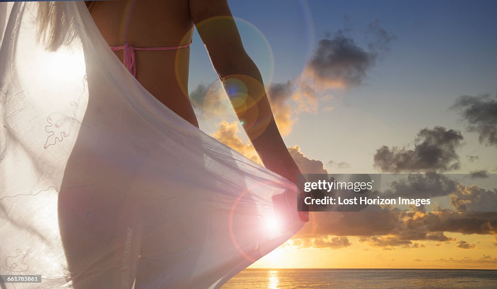 Rear view of young woman with scarf watching sunset on Miami Beach, Florida, USA