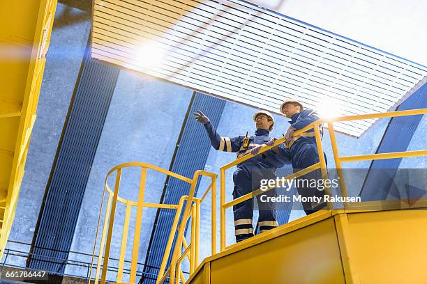 workers in generating hall in hydroelectric power station, low angle view - wasserkraft stock-fotos und bilder