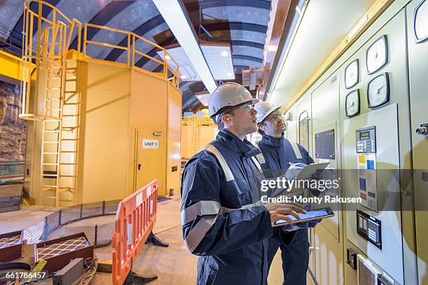 workers checking data in generating hall in hydroelectric power station - hydroelectric power station stock pictures, royalty-free photos & images