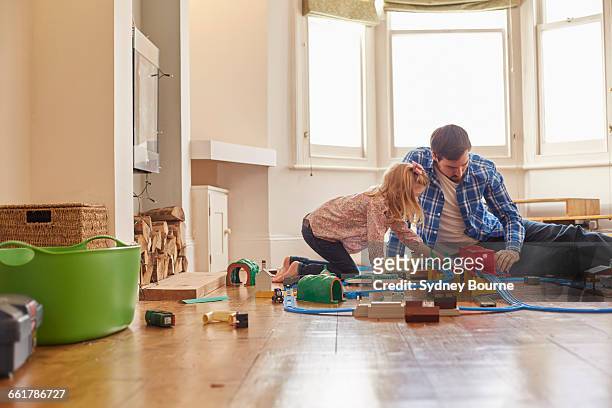 father and daughter playing with toy train set - model train stock pictures, royalty-free photos & images