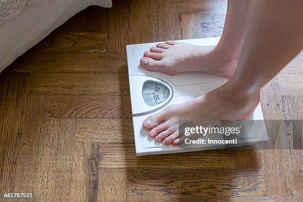 womans feet standing on bathroom scales - bathroom scale stock pictures, royalty-free photos & images