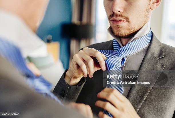 businessman wearing tie in front of mirror at hotel room - tied up ストックフォトと画像