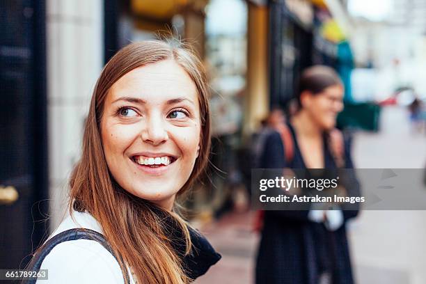 happy woman looking away at city street - dublin street imagens e fotografias de stock