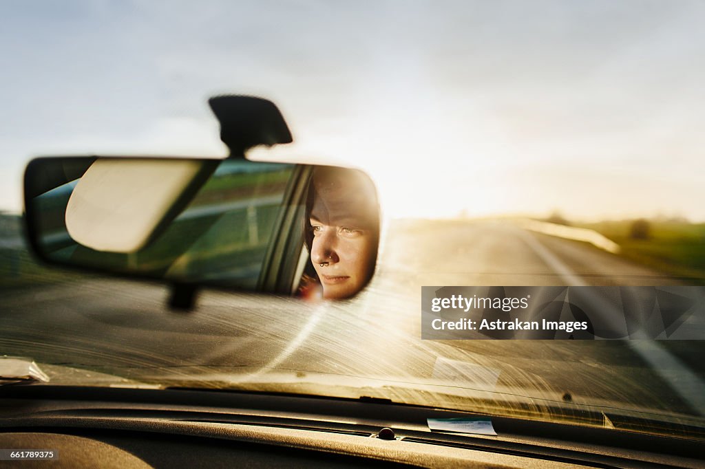 Reflection of woman in rear-view mirror