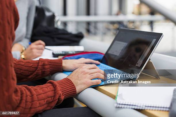 midsection of young male student using digital tablet in university - arabic keyboard fotografías e imágenes de stock