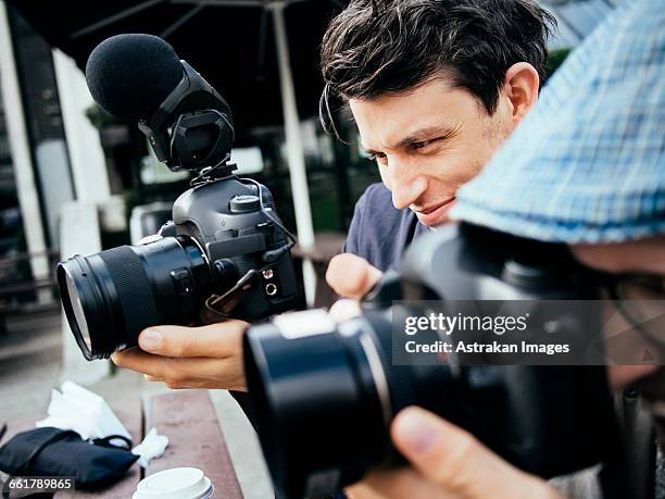 close-up of photographer using digital cameras outdoors - spiegelreflexcamera stockfoto's en -beelden