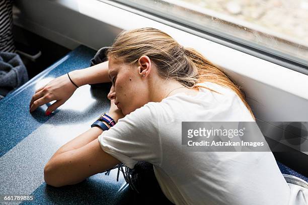 high angle view of tired businesswoman sleeping on table in train - woman sleeping table stock pictures, royalty-free photos & images