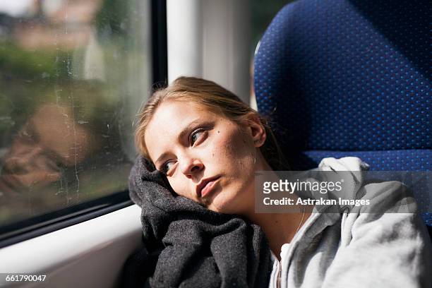 pensive businesswoman looking through train window - sad commuter stockfoto's en -beelden