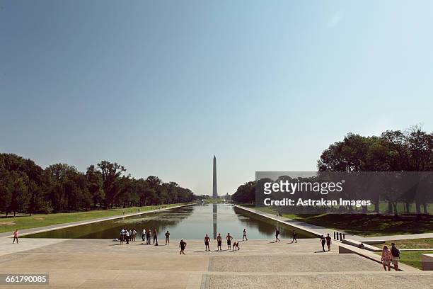 tourists at lincoln memorial park against clear blue sky - reflecting pool stock-fotos und bilder