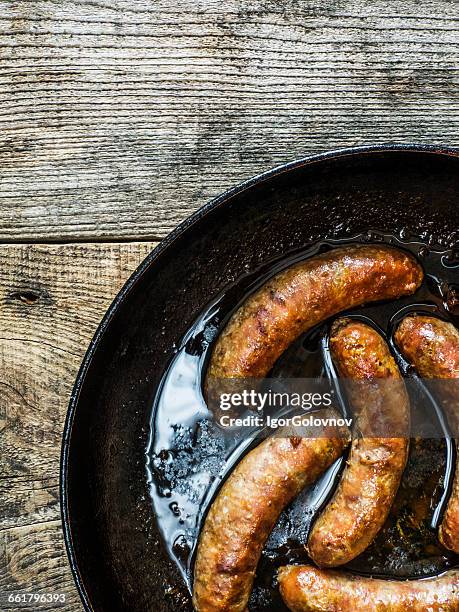 fried homemade sausages in frying pan - fried stock pictures, royalty-free photos & images