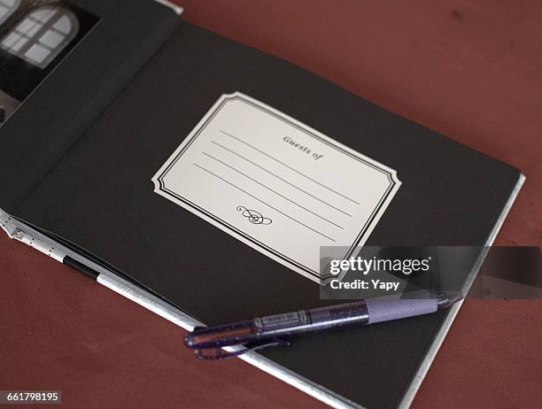 visitors book and pen on table - gastenboek stockfoto's en -beelden