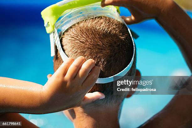boy putting on a diving mask - scuba mask stock pictures, royalty-free photos & images