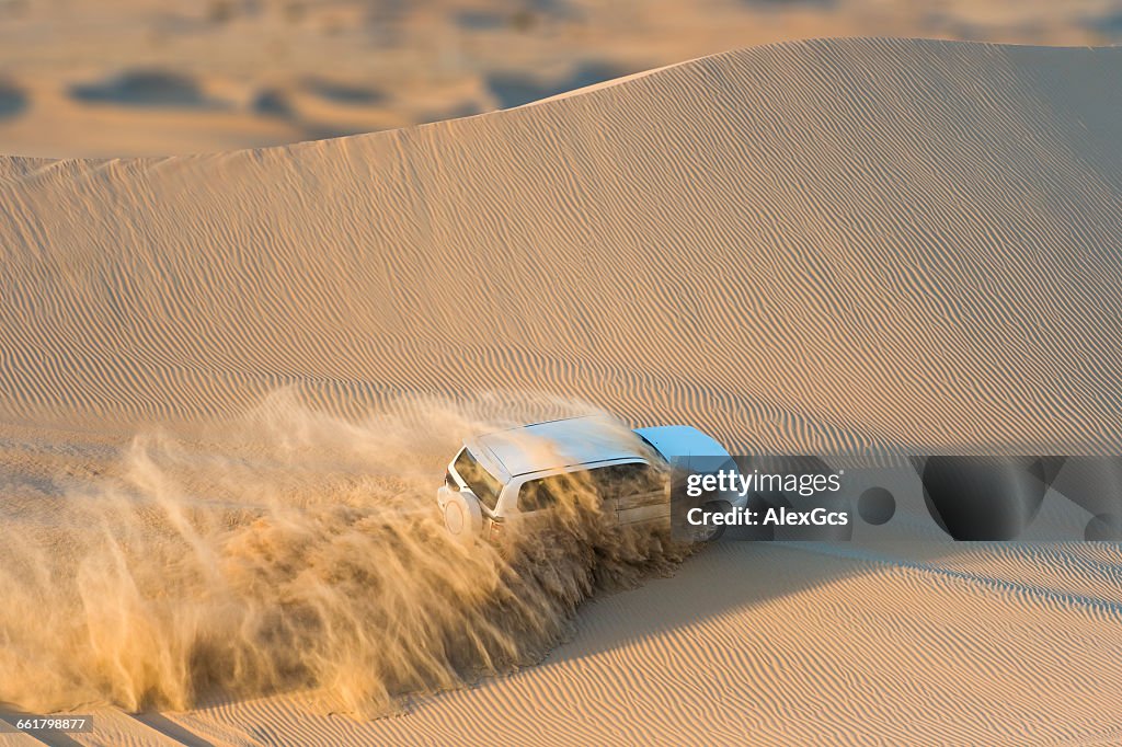 Off road vehicle driving through desert, Abu Dhabi, UAE
