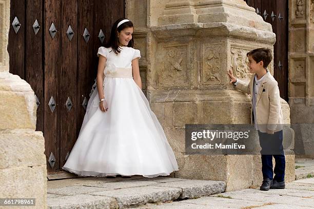 girl and boy outside church before first communion - communion fotografías e imágenes de stock