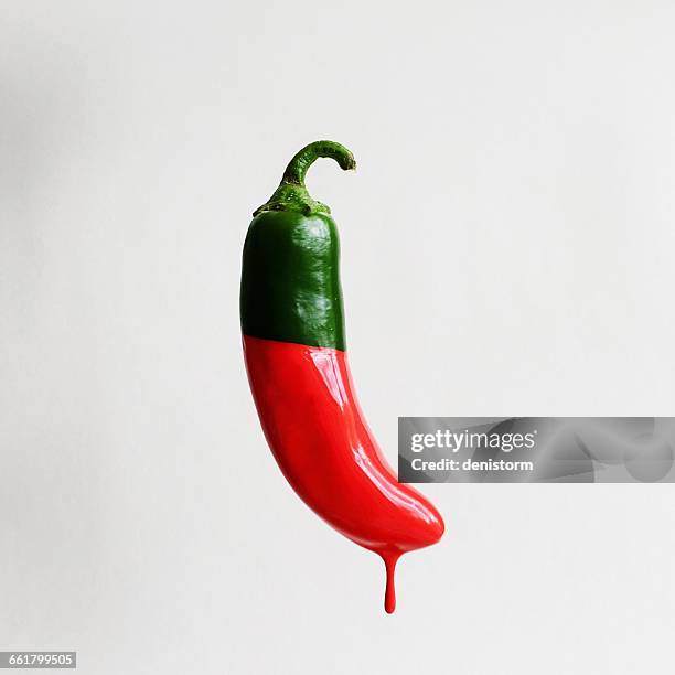 green chill dipped in red paint - chocolate dipped stock pictures, royalty-free photos & images