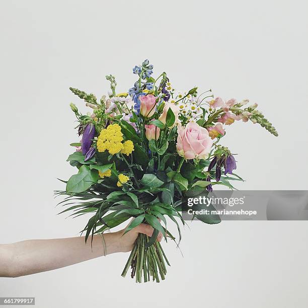 hand holding bouquet of flowers - bouquet imagens e fotografias de stock