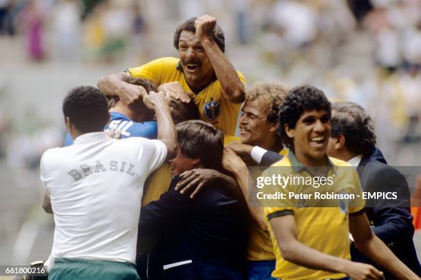 Brazil's Josimar is mobbed by jubilant teammates and coaches after scoring his team's second goal with a thirty yard screamer
