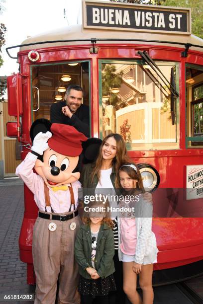 In this handout photo provided by Disney Parks, Actress Jessica Alba, husband Cash Warren and daughters Honor and Haven take a ride with Mickey Mouse...