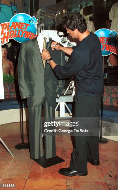 Actor Sylvester Stallone autographs the suit he donated from his latest film "Get Carter" September 25, 2000 at Planet Hollywood in New York City....