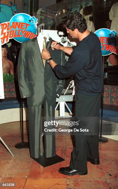 Actor Sylvester Stallone autographs the suit he donated from his latest film "Get Carter" September 25, 2000 at Planet Hollywood in New York City....