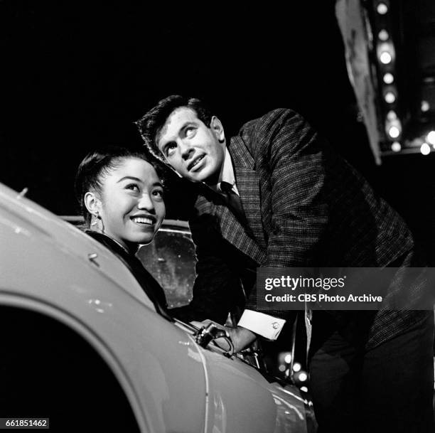 Neva Aki portrays Patty Yung and Mark Damon portrays Rod Campbell in the CBS television police drama program, "The Lineup" episode titled 'The...