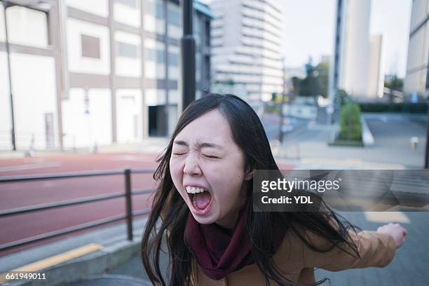 a woman cries loud outside. - asian woman angry stock pictures, royalty-free photos & images