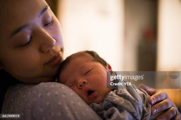 a mother looks his newborn baby gently. - mother sleeping baby bildbanksfoton och bilder