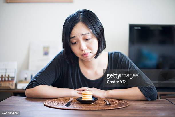 a woman on a diet moons at small pancakes. - little effort stock pictures, royalty-free photos & images